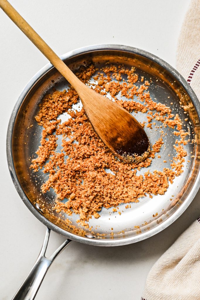 Breadcrumbs toasting in a pan.