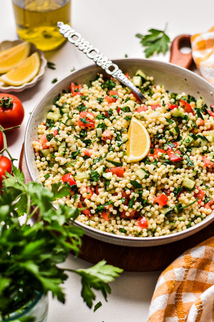 Tabouleh salad with acini di pepe packed with herbs and veggies in a bowl.