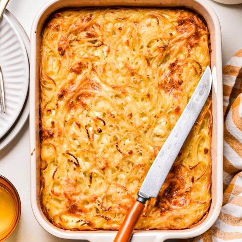 Baked spaghetti feta pie in a baking dish before being sliced.