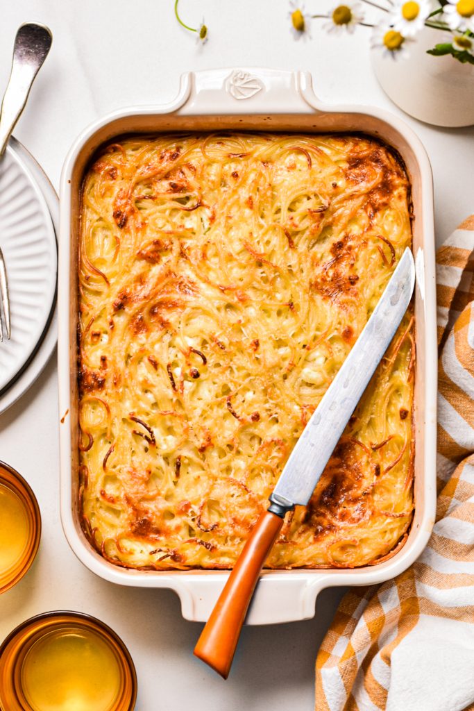 Baked spaghetti feta pie in a baking dish before being sliced.