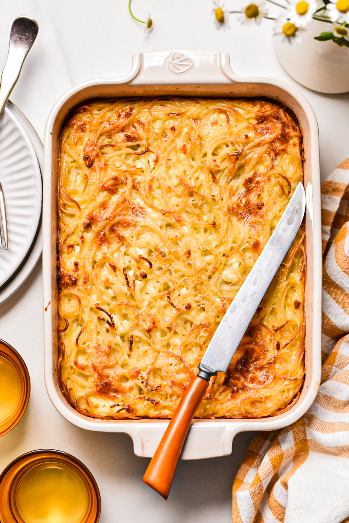 Baked spaghetti feta pie in a baking dish before being sliced.