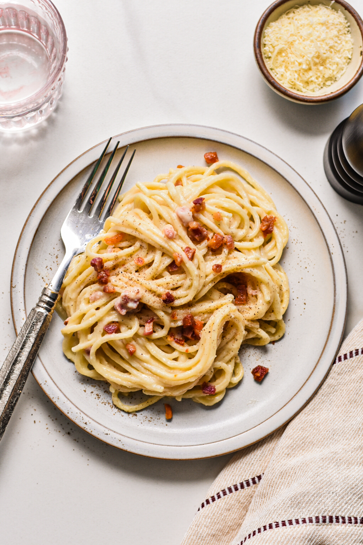 Overhead shot of creamy pancetta cauliflower pasta served on a plate with a fork.
