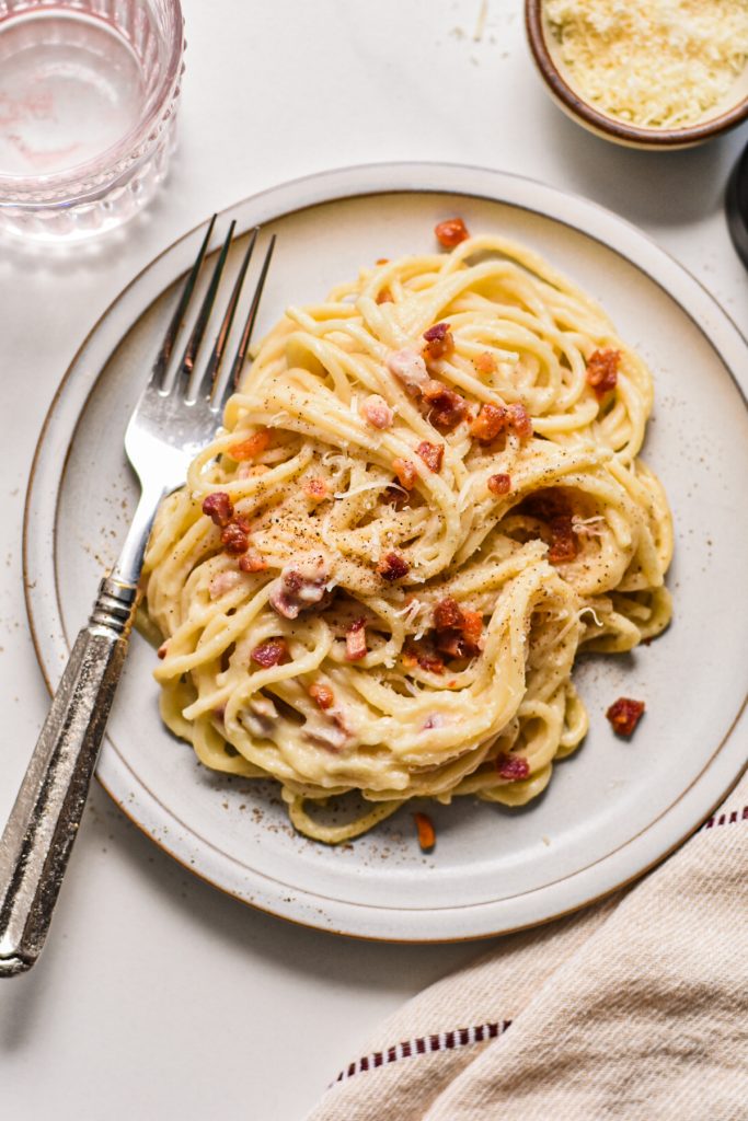 Overhead shot of creamy pancetta cauliflower pasta served on a plate.
