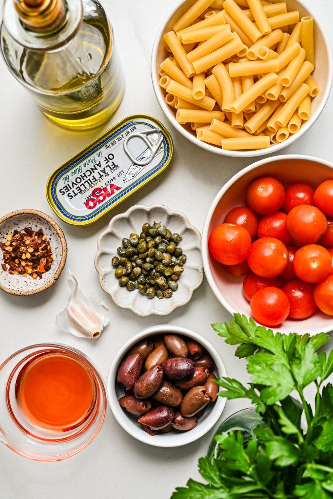 Ingredients needed to make puttanesca pasta salad.