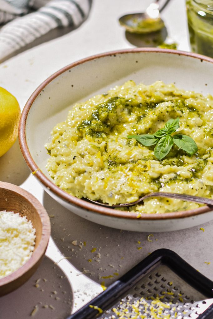 Creamy pesto pastina with gorgonzola cheese served in a shallow bowl with basil on top.