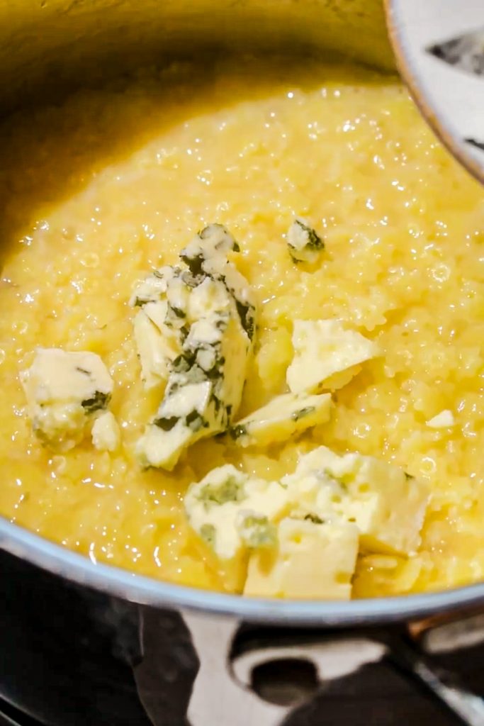 Adding the gorgonzola cheese to the cooked pastina pasta.