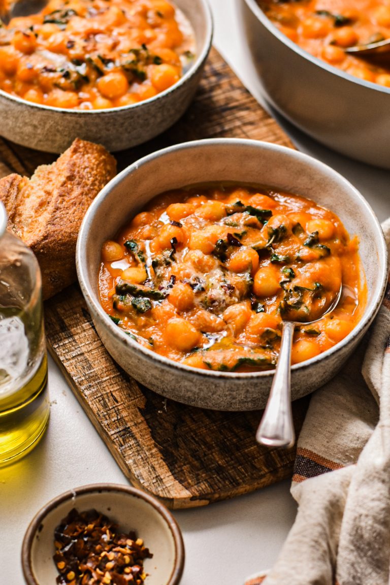 Fennel tomato gnocchi soup with kale in a bowl with a spoon.