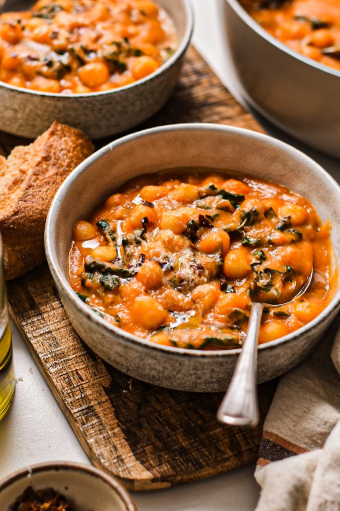 Fennel tomato gnocchi soup in a bowl with a spoon.