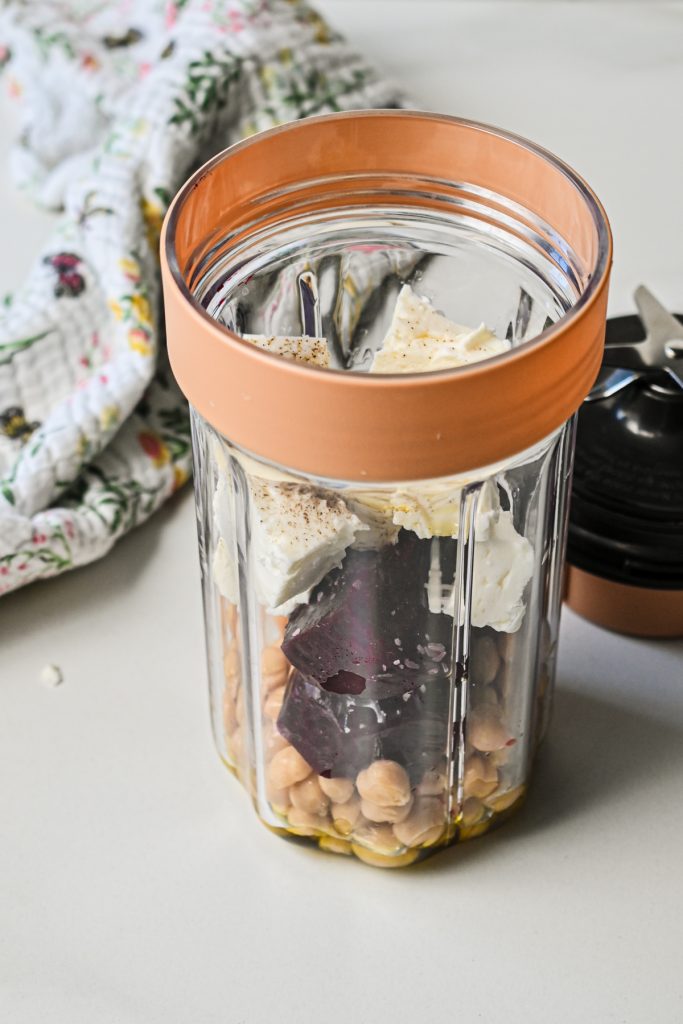 Blending the beets, feta, and chickpeas in a small blender.