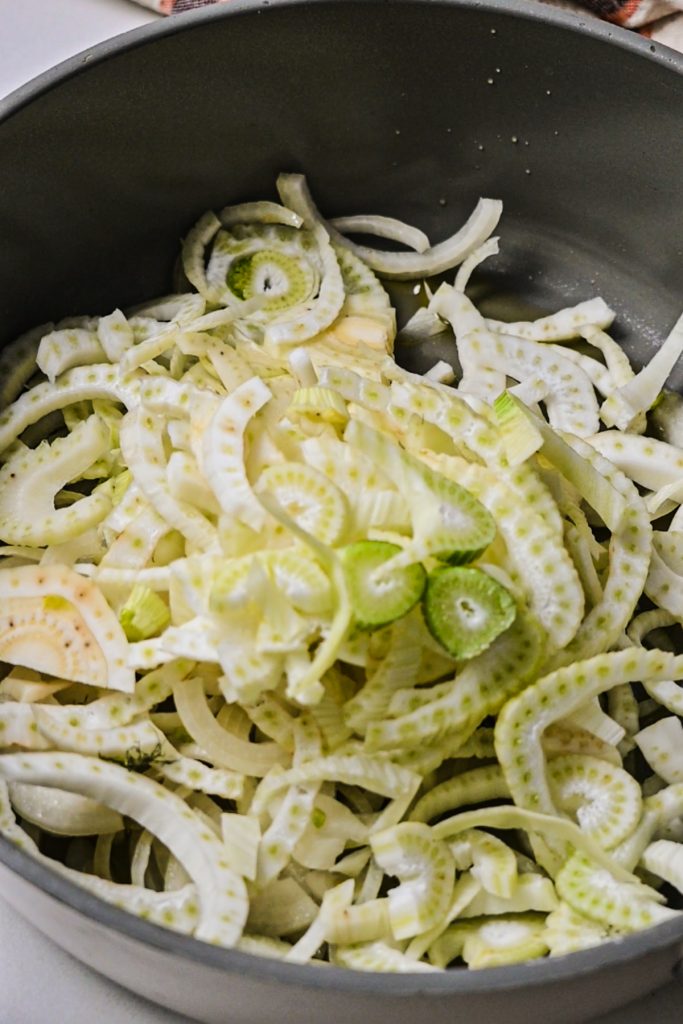 Sliced fennel cooking in a skillet.