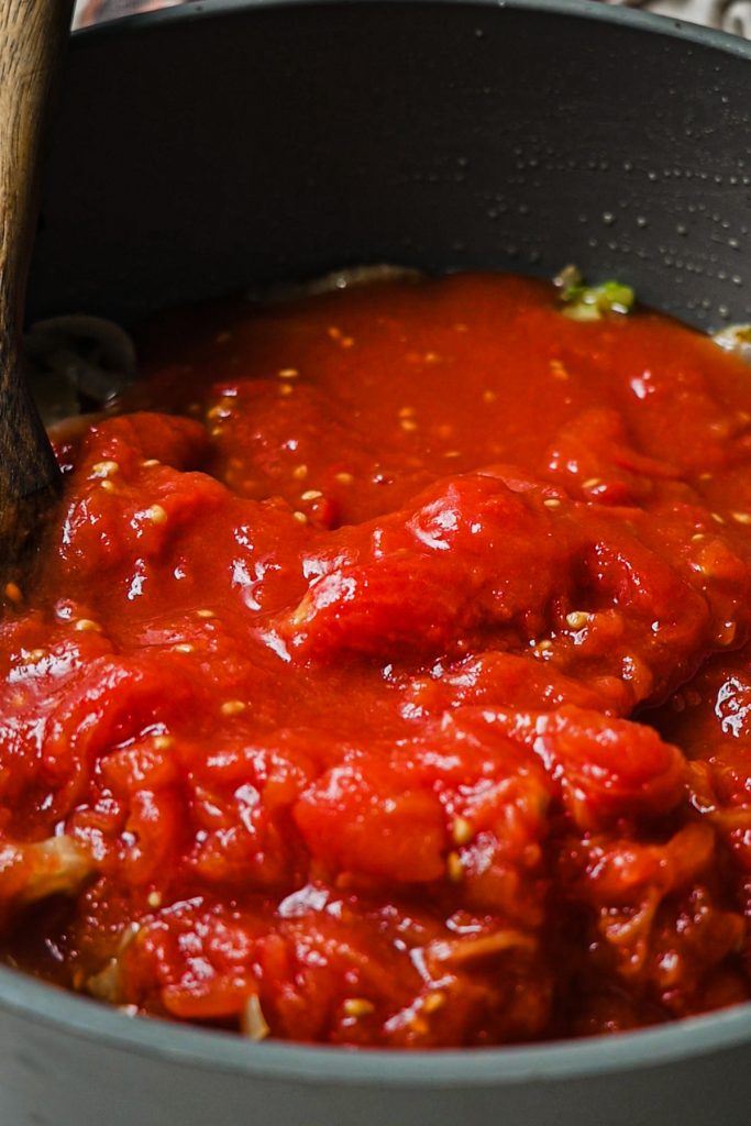 Tomatoes added to the onions and fennel in a large skillet.