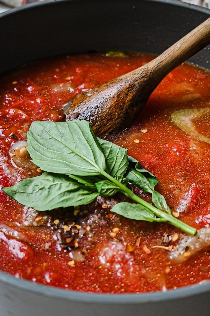 Fresh basil and chili flakes added to the skillet.