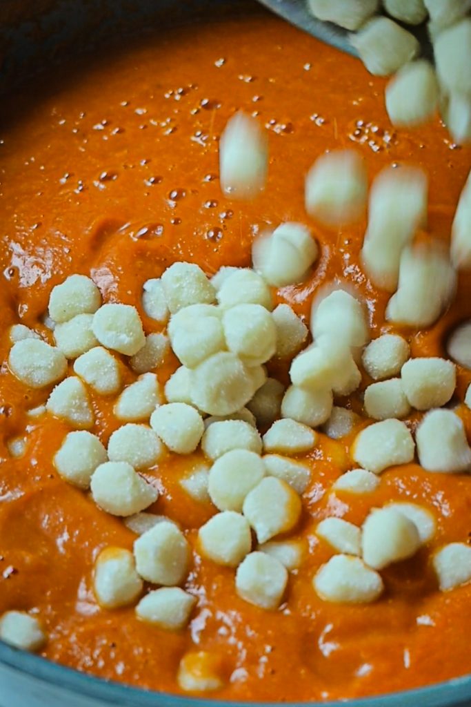Gnocchi added to the tomato soup in a skillet.