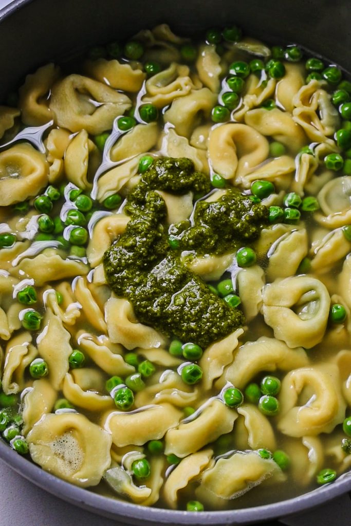 Pesto added to the tortellini, peas and broth.